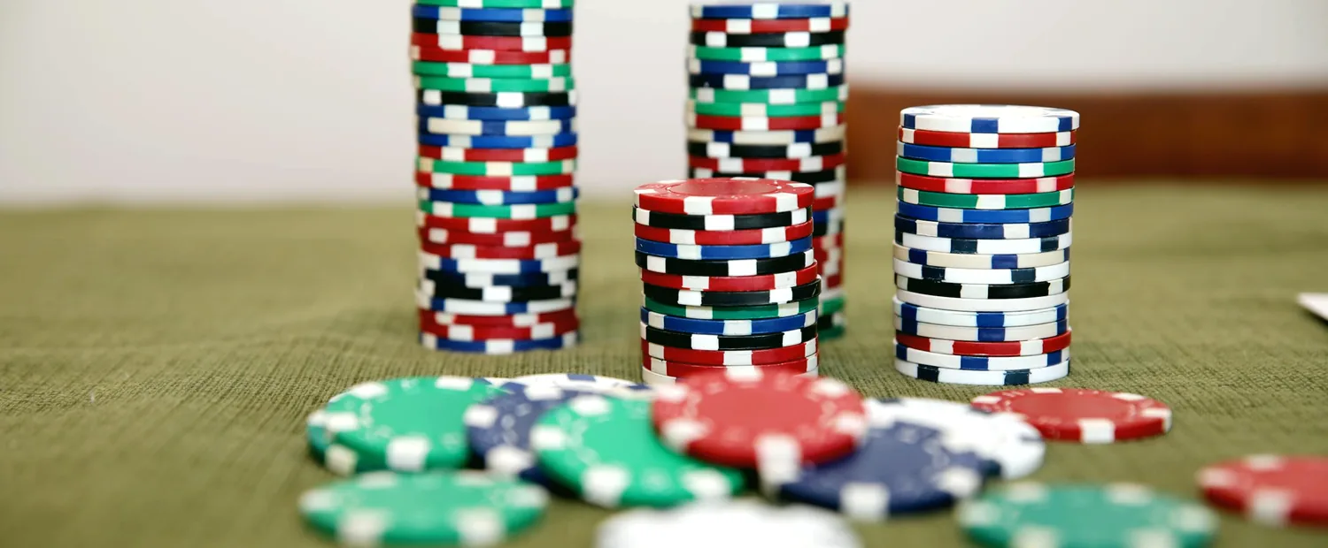 Stacks of poker chips on green felt — the iPoker Network table economy behind Bet365 Poker